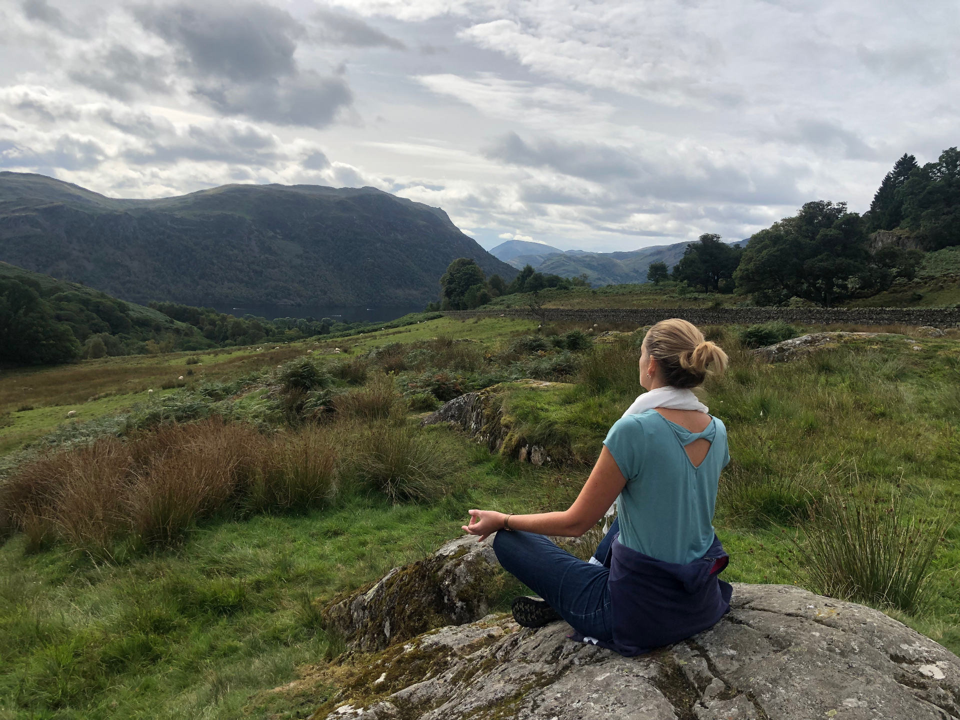 Katy meditating on a rock overlooking the Lake District